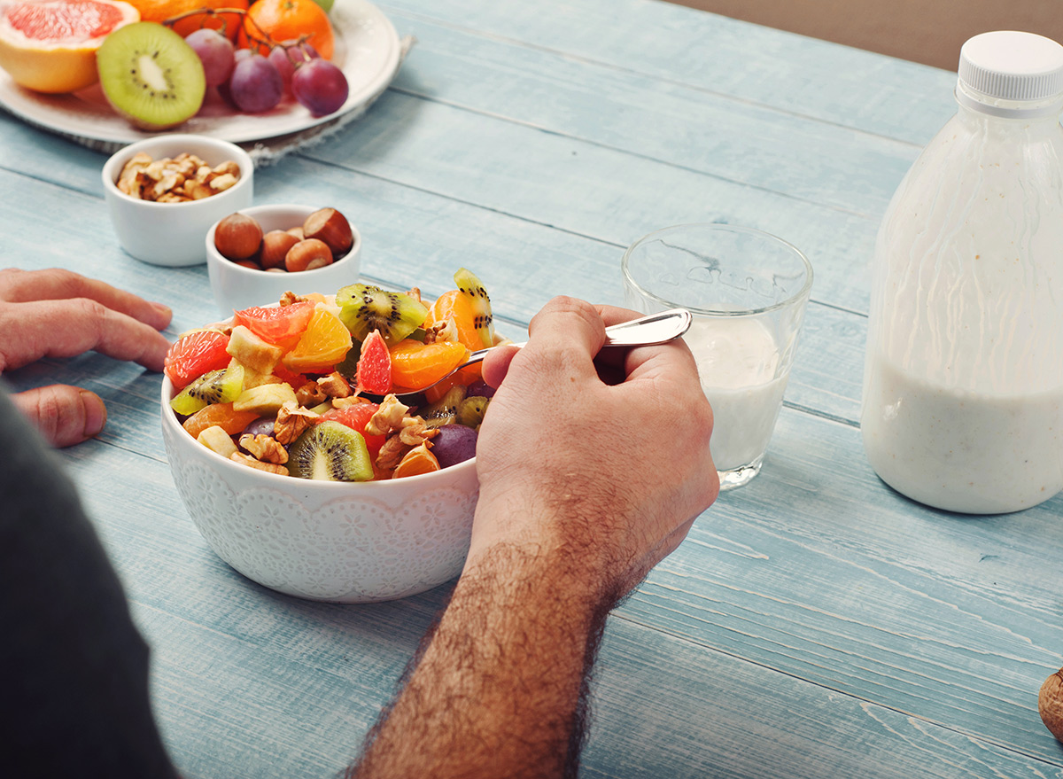 Man eating bowl of fruit