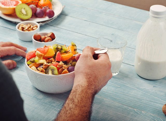 man eating bowl of fruit - Medplus