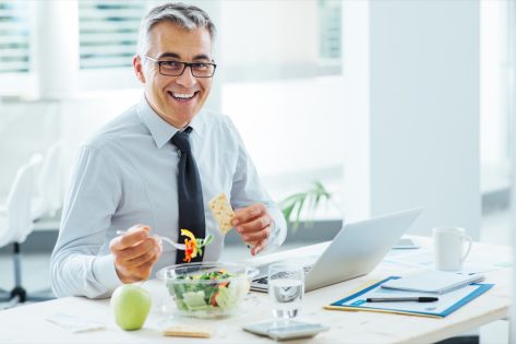 older businessman eating salad