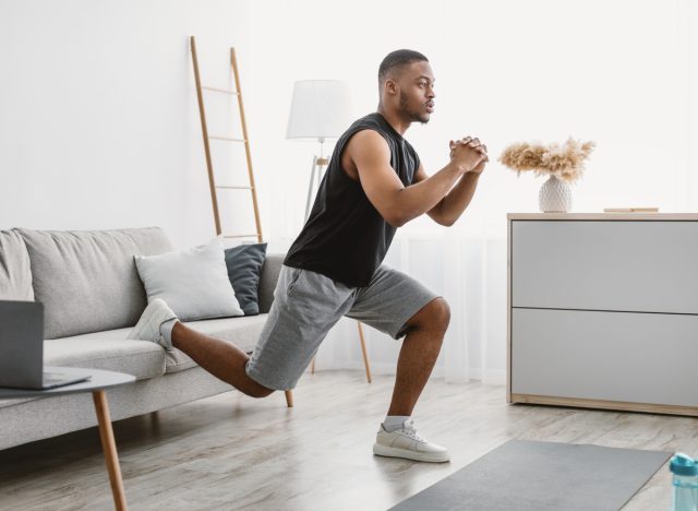 man living room working out split squat