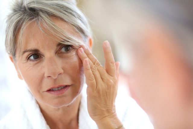 Senior woman applying anti-wrinkles cream