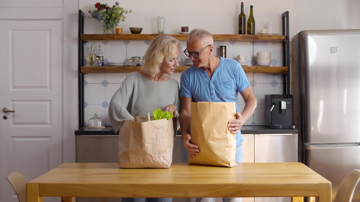 older couple unpacking groceries at home