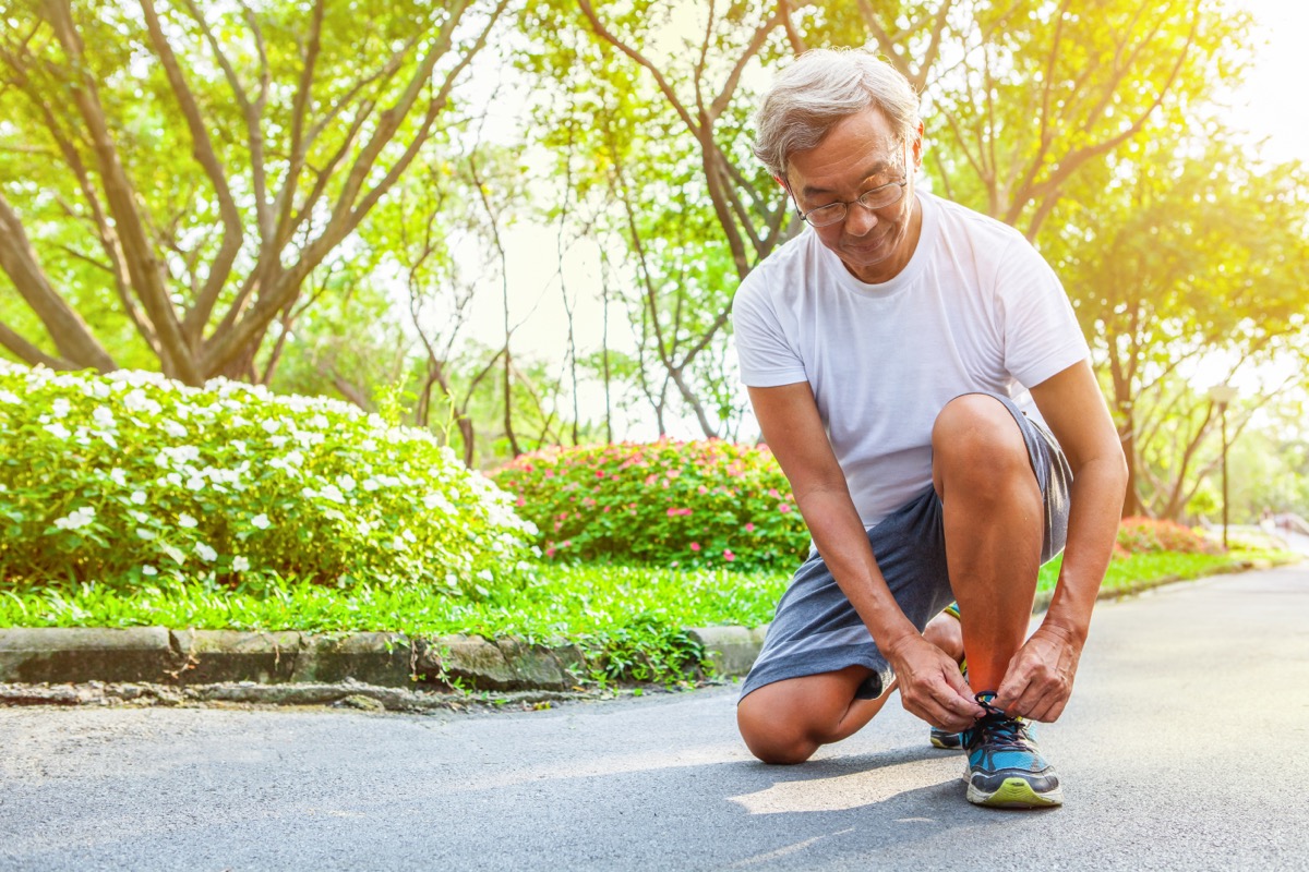 older man lacing up sneakers