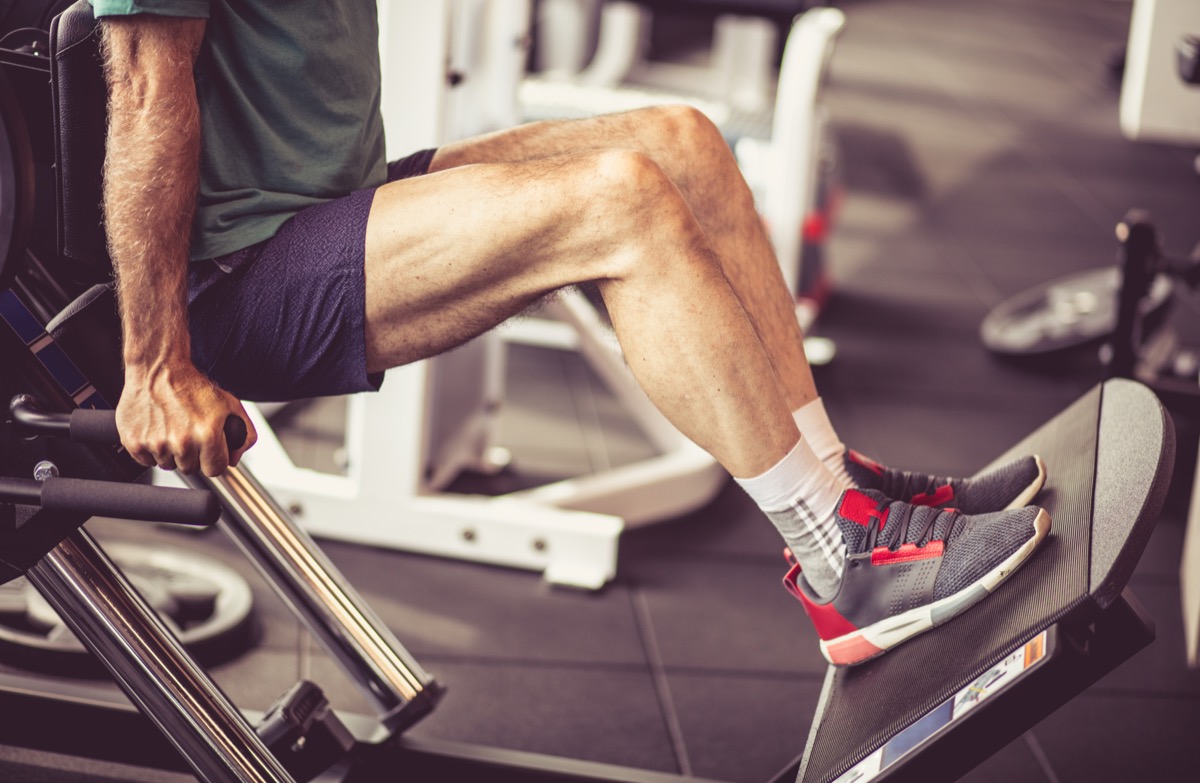 older man doing leg weight exercises