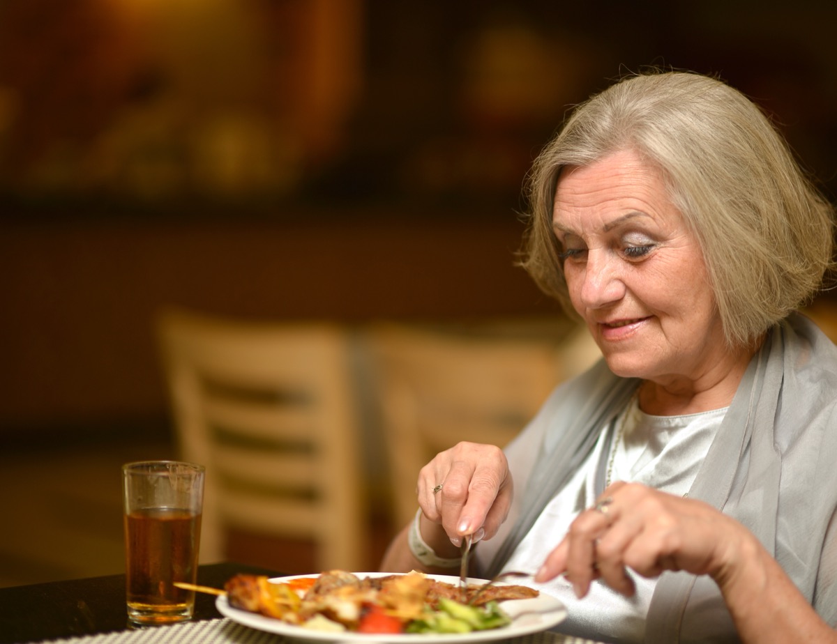 older woman eating alone at restaurant