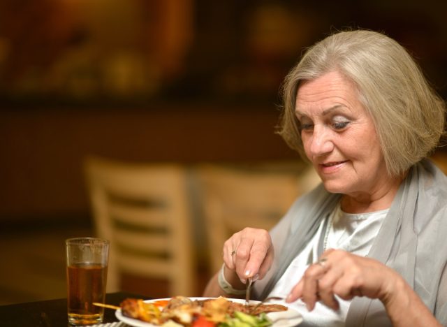 older woman eating alone at restaurant