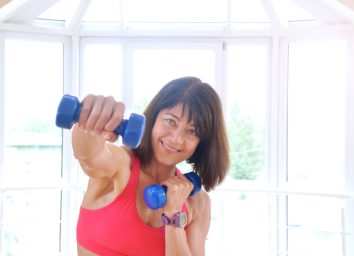 middle-aged woman working out with dumbbells