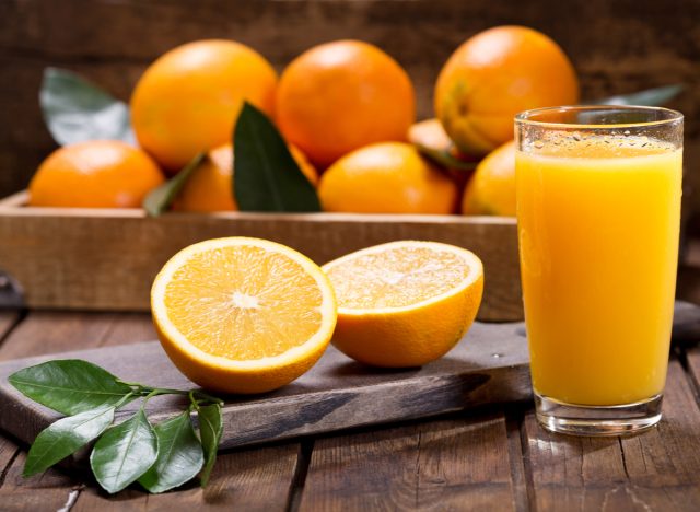 An orange with a glass of orange juice