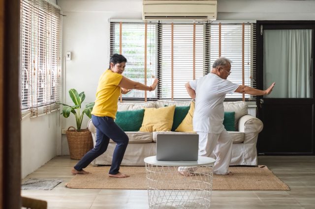 senior couple doing yoga exercise at home