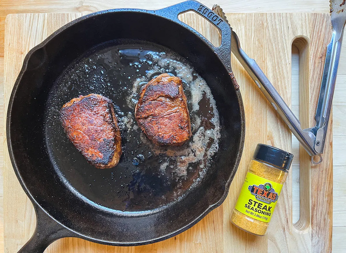 cooked texas roadhouse butcher shop steak filets in a cast iron skillet