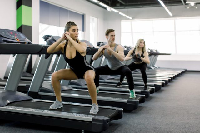 group of adults walking sideways on the treadmill