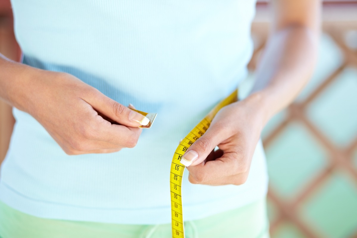 Woman measuring her waist