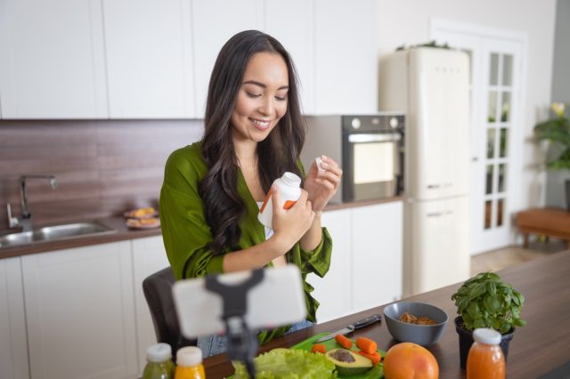 Smiling young woman looking at her vitamins