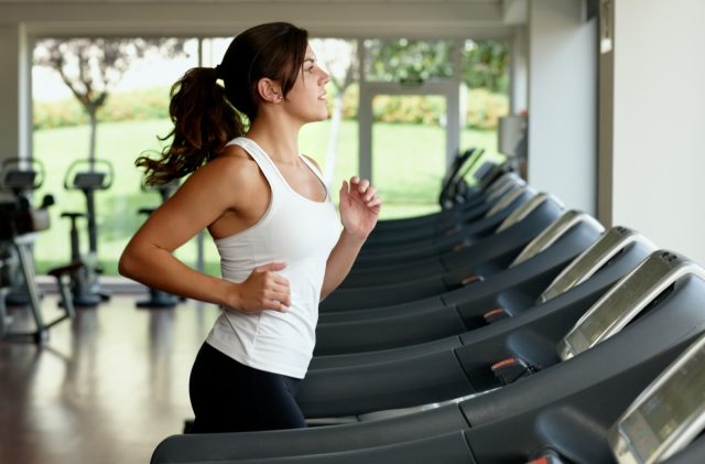young woman running on treadmill