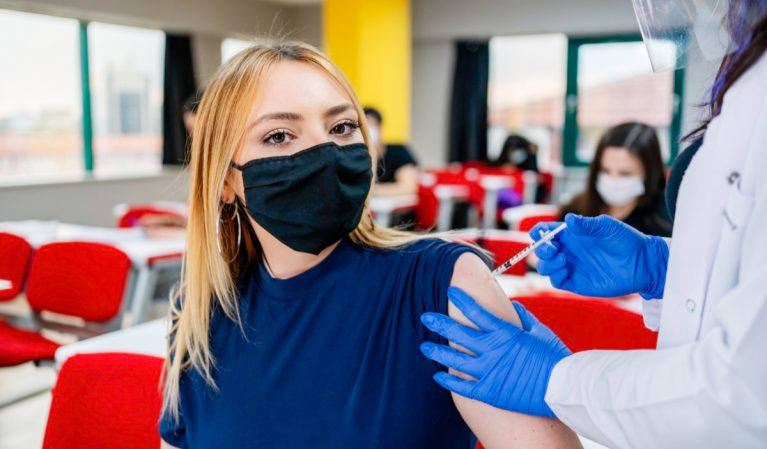 Nurse gives students a vaccination in school during coronavirus pandemic