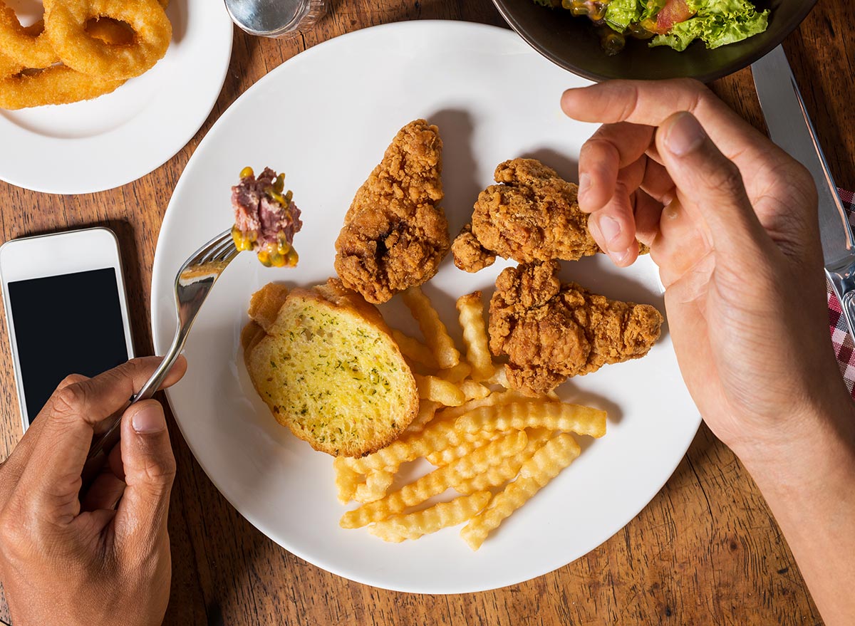 hands near plate of fried foods
