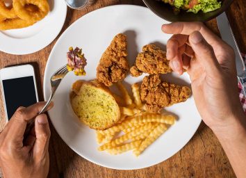 hands near plate of fried foods