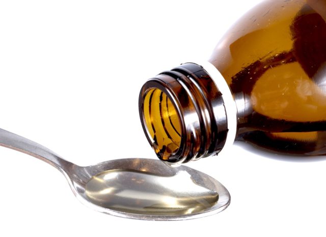 Cold medicine poured on a spoon.