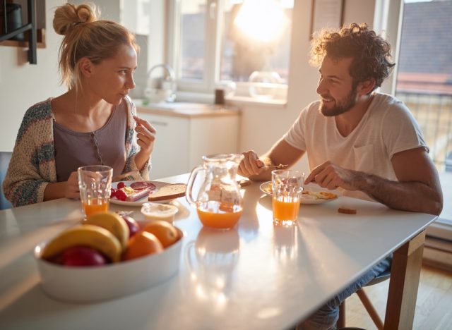 young couple eating breakfast at kitchen table