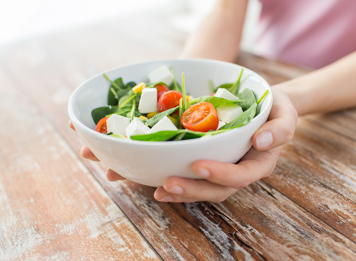 holding a bowl of salad