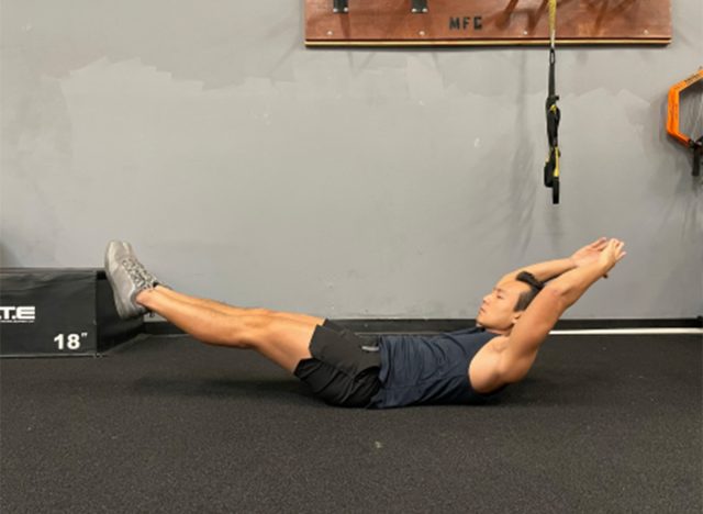 trainer performing hollow hold exercise