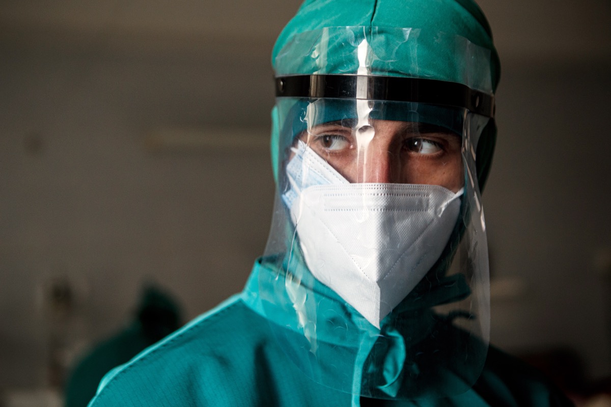 Doctor in PPE that includes a face shield and two face masks is on duty in hopsital.