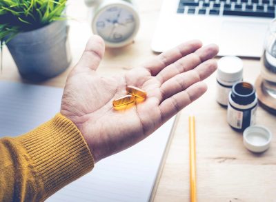 man holding supplement at his desk in the winter