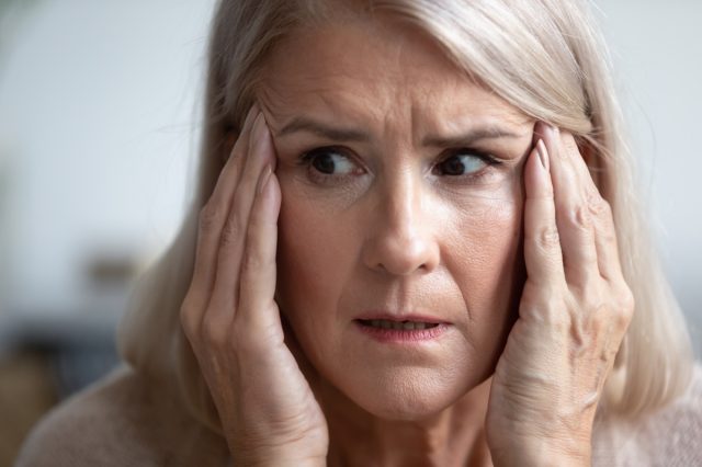 Close up of mature woman look in distance thinking.