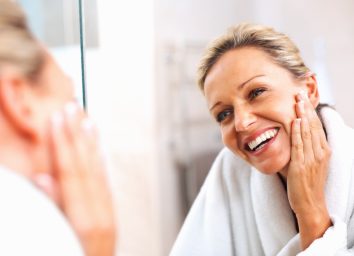 Happy mature woman admiring herself in the mirror