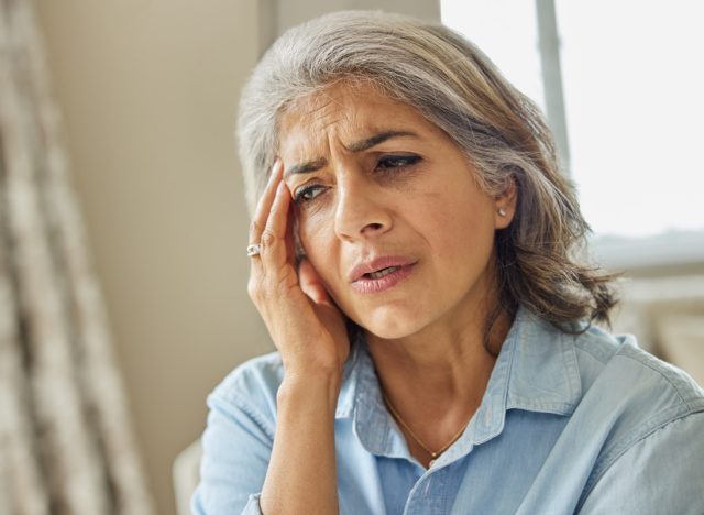 Mature Woman At Home Suffering From Headache Or Memory Loss