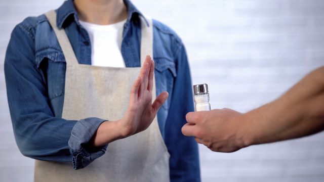 Chef refusing salt in cooking, healthy nutrition to prevent heart disease
