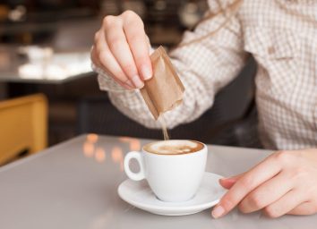 pouring sugar into coffee