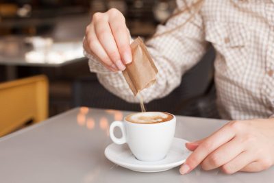 pouring sugar into coffee