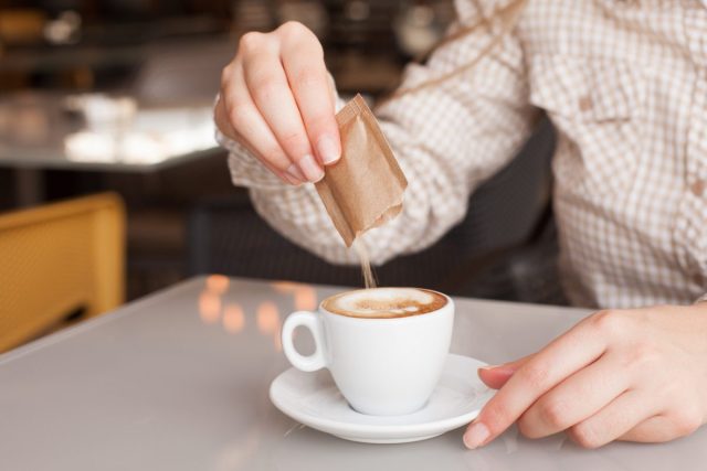 Zucker in Kaffee gießen