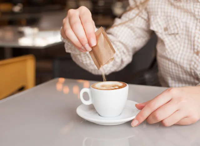 pouring sugar into coffee