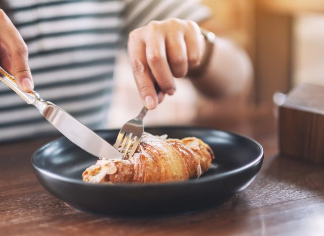 woman eating croissant