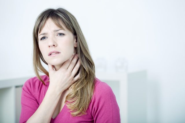 Woman suffering from sore throat.