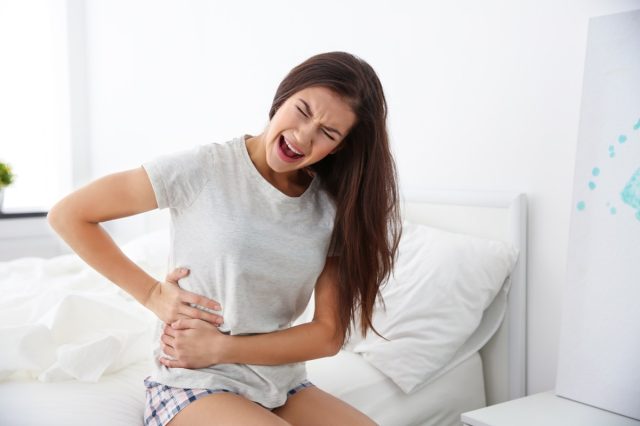 Young woman suffering pain at bedroom