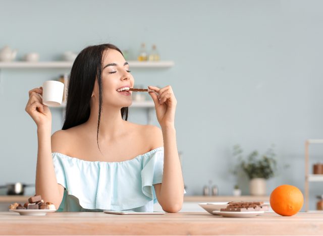 happy woman enjoys chocolate bar at counter