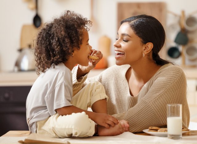 mother and son enjoying cookies in kitchen