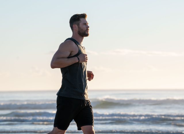 chris hemsworth running on a beach