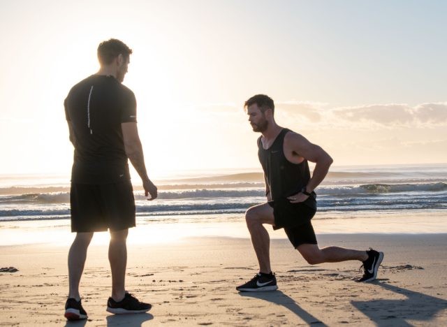 chris hemsworth doing lunges on the beach