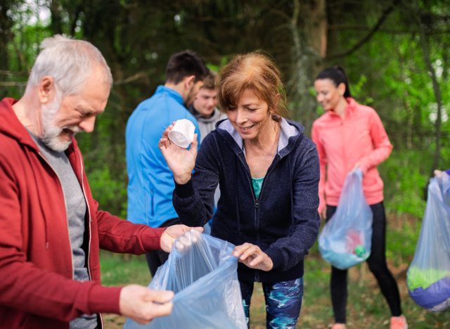 senior couple collecting trash while plogging