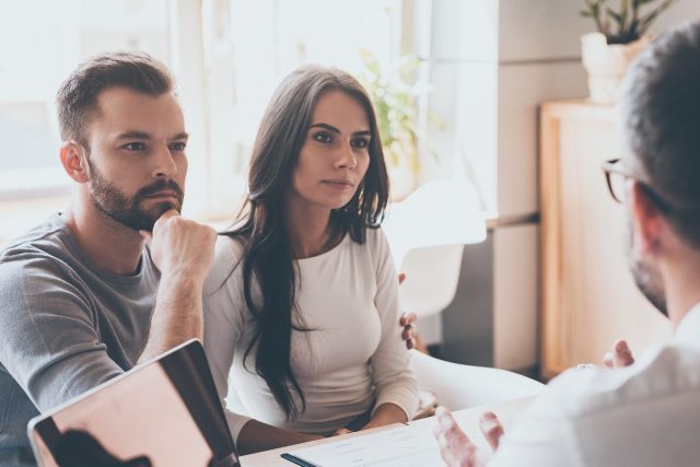 couple listening to doctor in his office