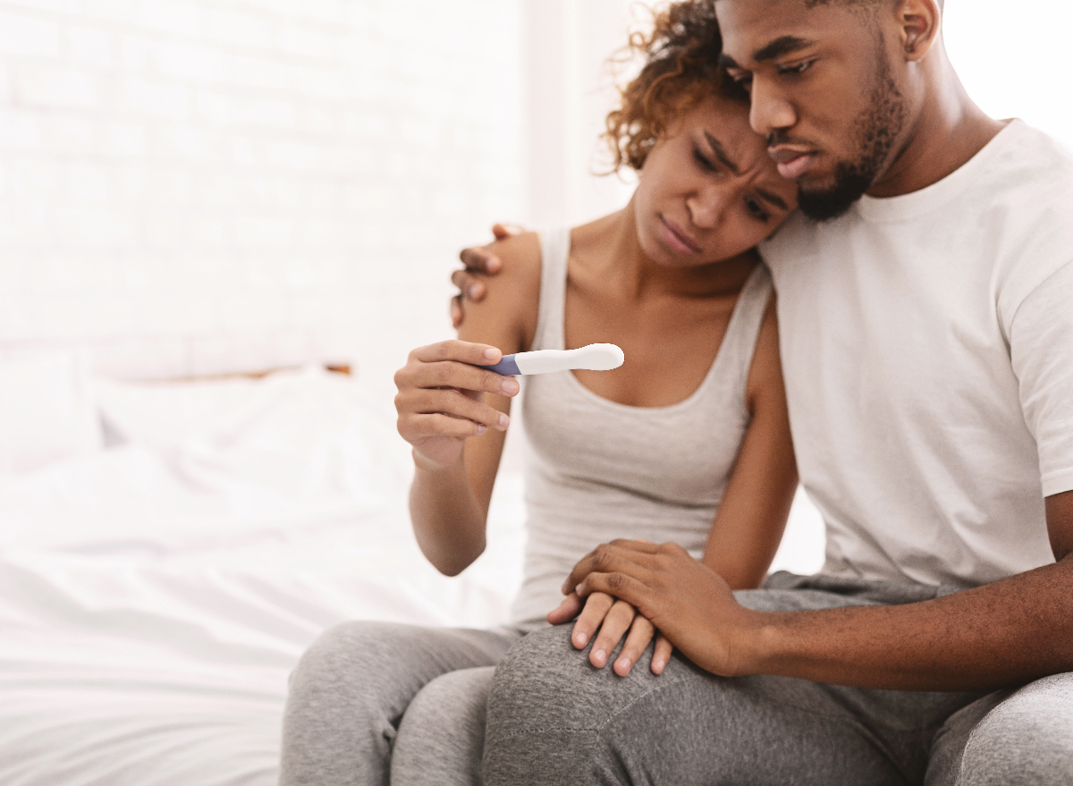 couple looking sad at negative pregnancy test