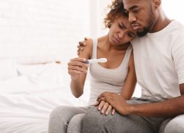 couple looking sad at negative pregnancy test