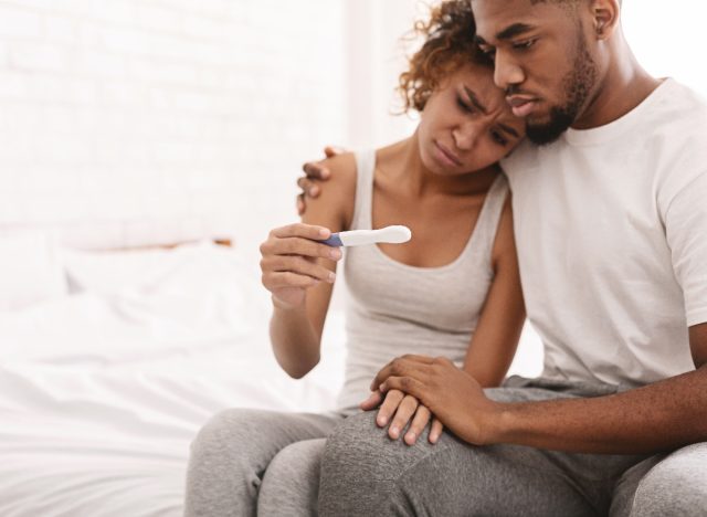 couple looking sad at negative pregnancy test
