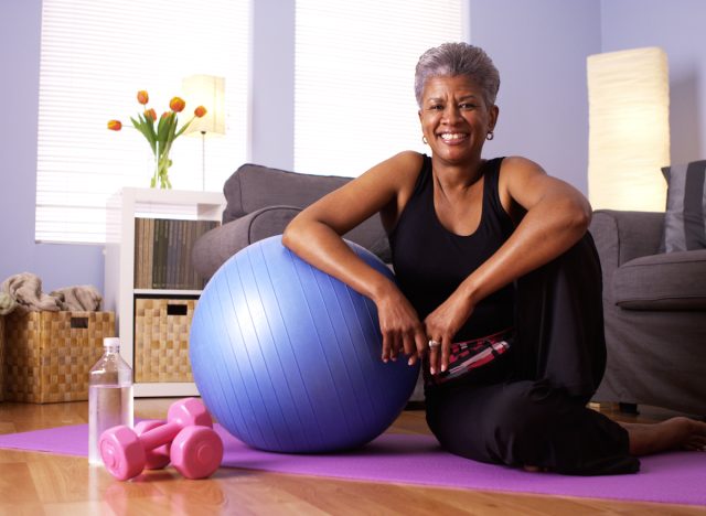 happy older woman sitting on yoga mask