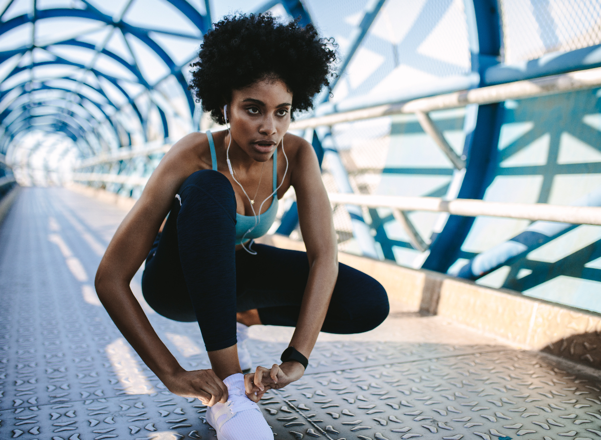 focused woman tying shoes