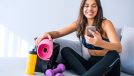 woman smiling while checking workout app